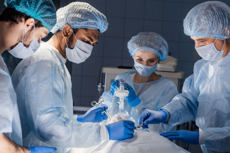 A team of surgeons performs a surgical operation.